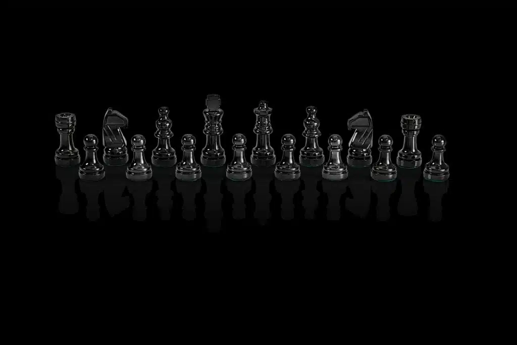 Pièces d'échecs noires du Chess Genius Pro alignées sur fond noir