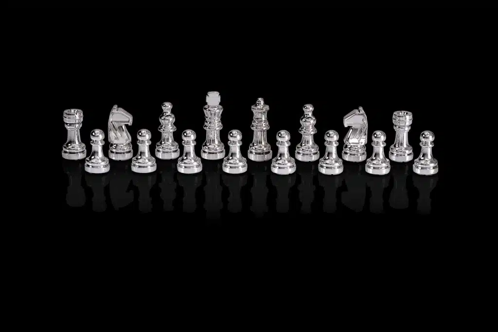 Pièces d'échecs argentées du Chess Genius Pro alignées sur fond noir