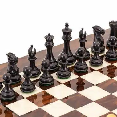 Pièces d'échecs ébène noires alignées sur l'échiquier en bois de bruyère