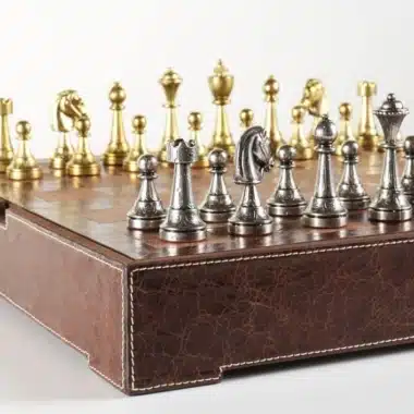 Vue d'ensemble du jeu complet avec pièces dorées et argentées sur échiquier en cuir
