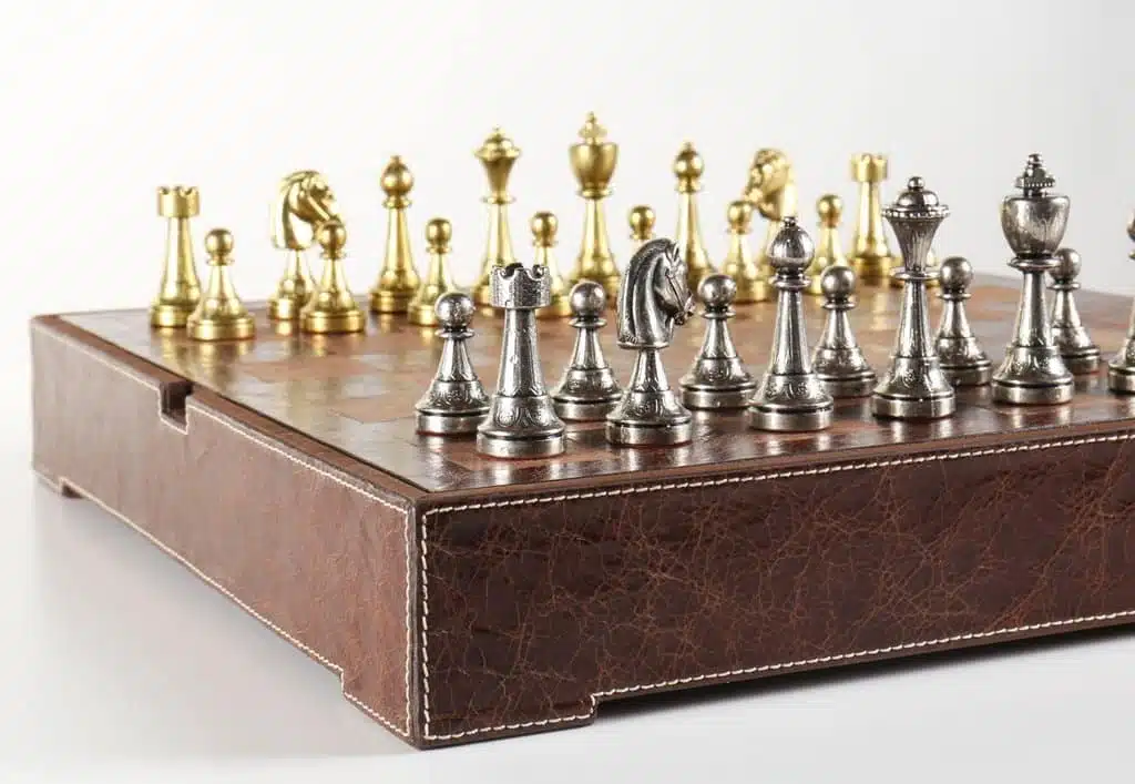Vue d'ensemble du jeu complet avec pièces dorées et argentées sur échiquier en cuir