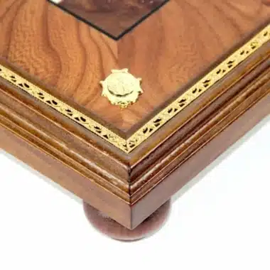 Angle du pied en bois d'orme avec liseré doré et médaillon gravé, vue détaillée