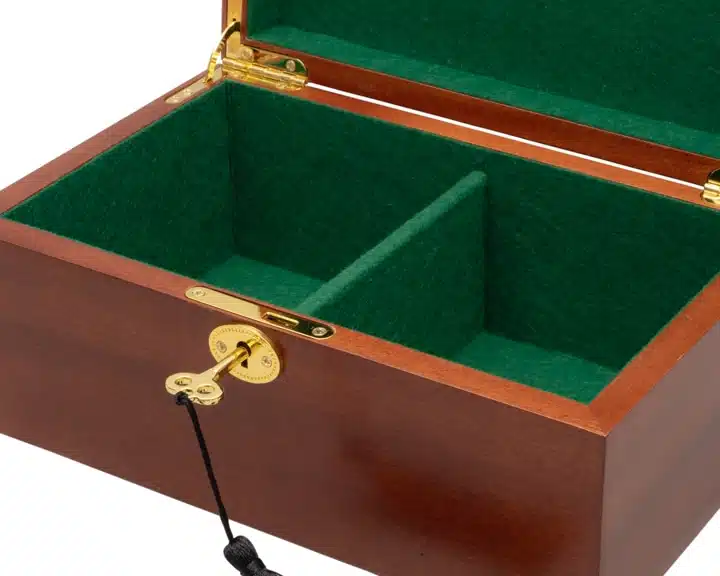 Détail de la serrure dorée et de la clé du coffret de rangement en acajou