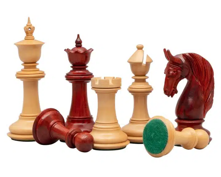Détail des pièces d'échecs en padouk et buis, base feutrée visible