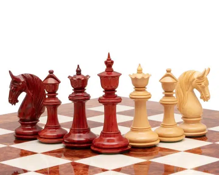 Pièces d'échecs en bois de padouk rouge et buis clair sur échiquier