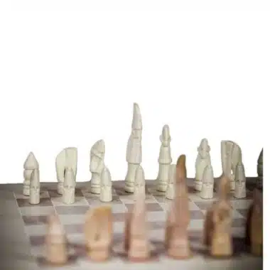 Jeu d'échecs en pierre ollaire, rangée de pièces claires face aux pièces foncées