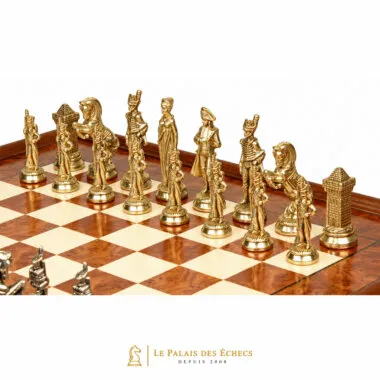 Pièces dorées du jeu d'échecs Napoléon alignées sur l'échiquier en bois d'orme