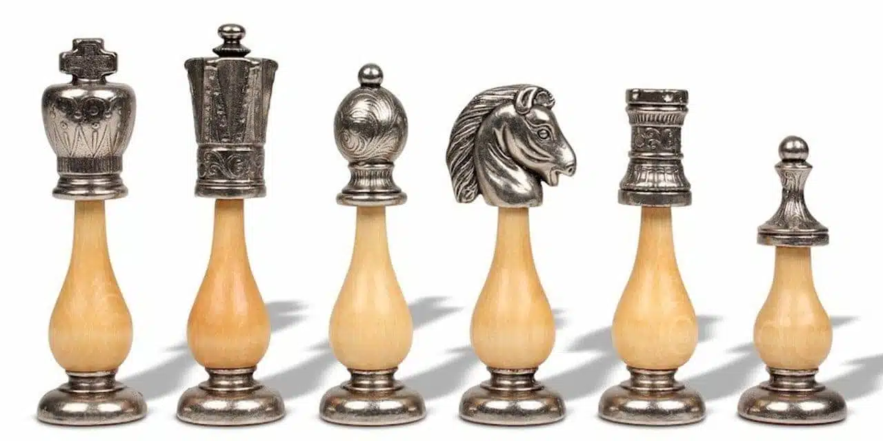 Roi, pion, cavalier et tour argentés sur socle en bois clair