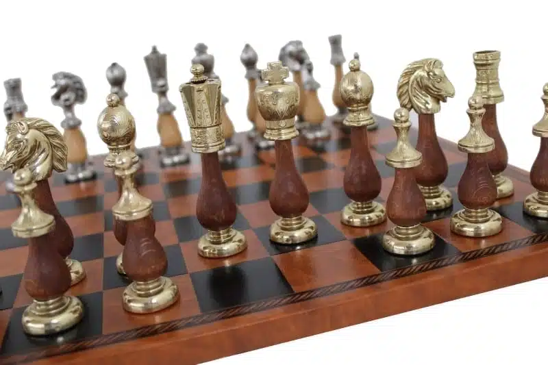 Pièces d'échecs en bois et métal alignées sur l'échiquier marron