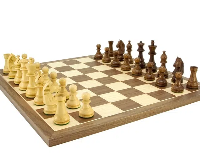 Vue d'ensemble en angle du jeu d'échecs complet sur échiquier en noyer