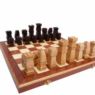 Jeu d'échecs en bois cubique posé sur l'échiquier pliant ouvert