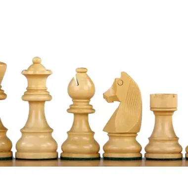 Pièces claires en buis, roi, dame, fou, cavalier et tour disposés sur le plateau