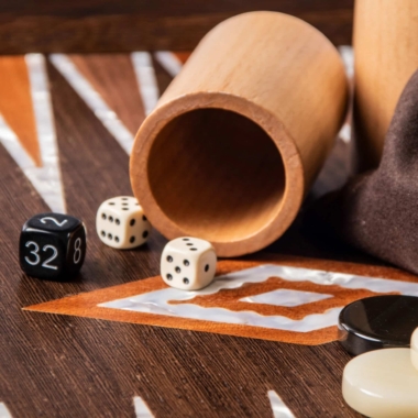 Gobelet à dés en bois avec dés classiques et de doublage posés sur le plateau