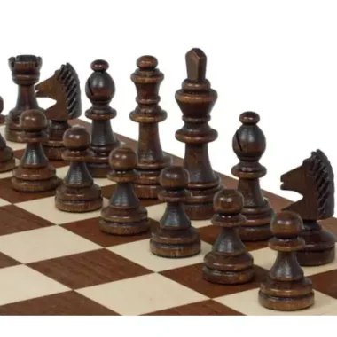 Pièces d'échecs foncées en gros plan alignées sur l'échiquier marqueté