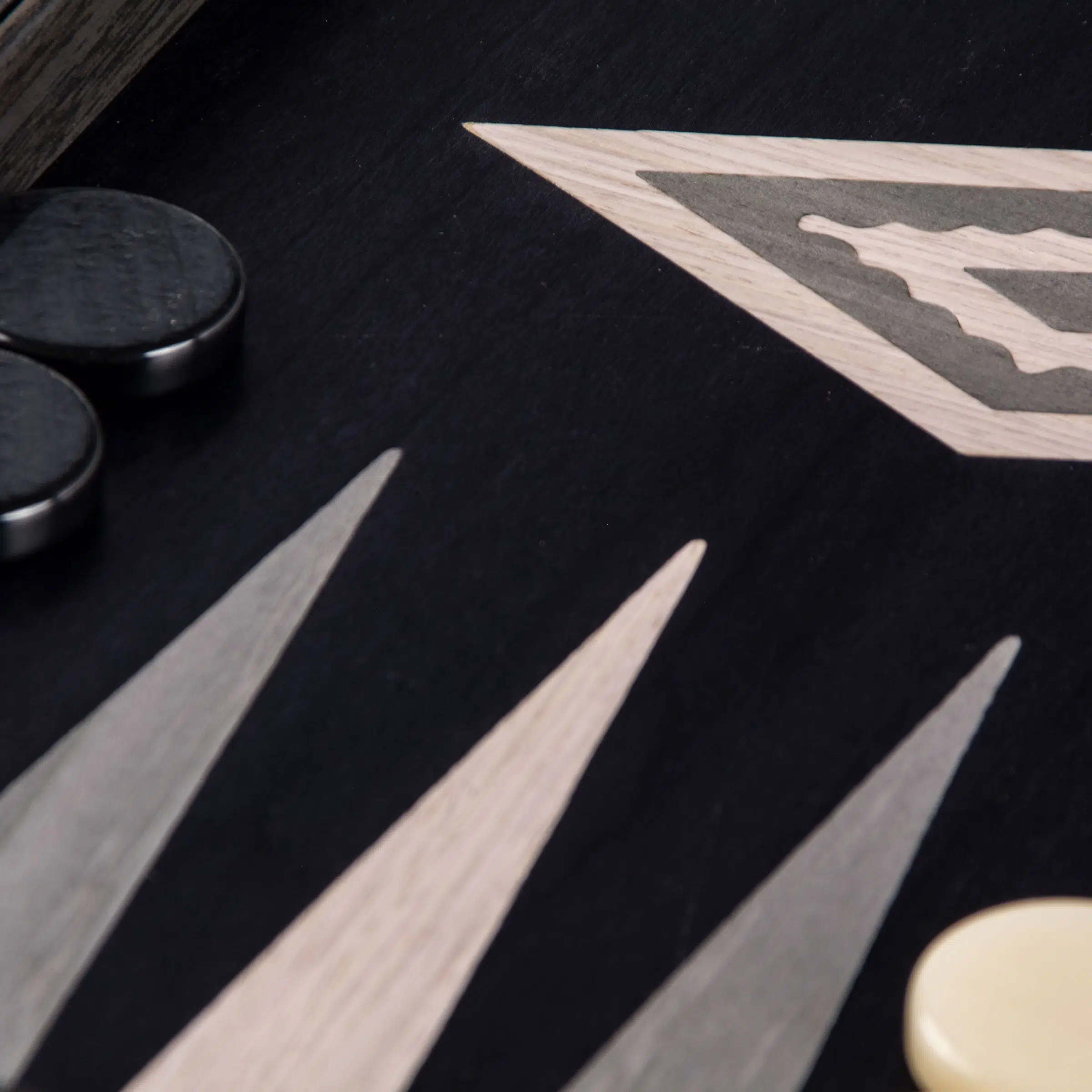 Zoom sur le motif graphique du backgammon Vavona, pions noirs et beiges inclus